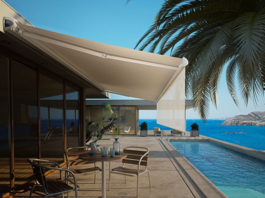 store banne coffre blanc avec toile beige et lambrequin enroulable au bord d'une piscine